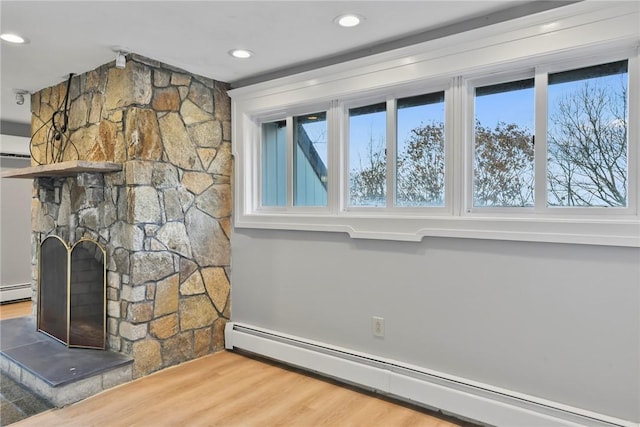 details featuring wood-type flooring, a fireplace, and a baseboard radiator