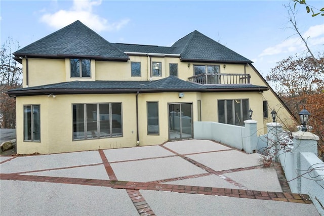 back of property featuring a patio area and a balcony