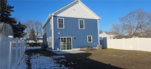 snow covered house featuring central AC