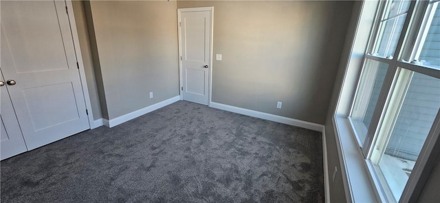 unfurnished bedroom featuring dark carpet