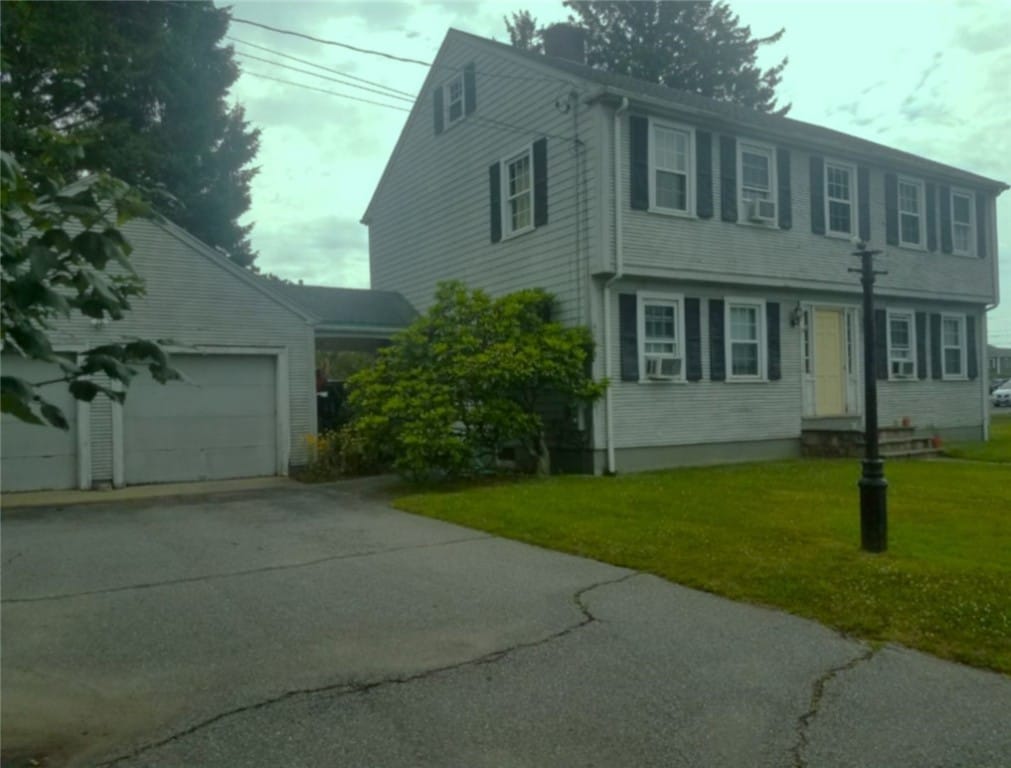 colonial home with a front yard and a garage