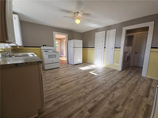 kitchen featuring ceiling fan, wood-type flooring, white appliances, and sink