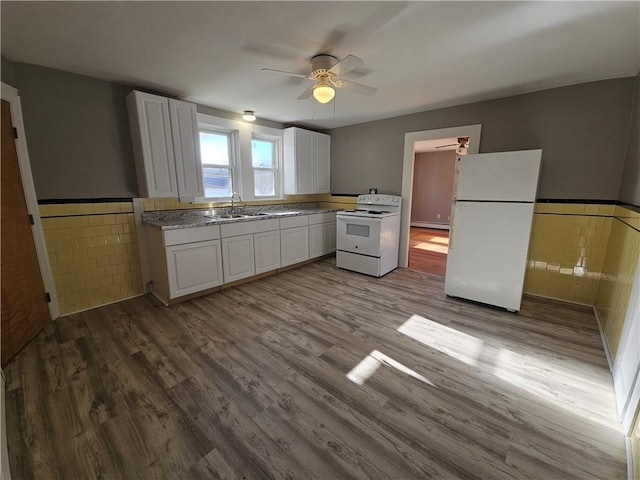 kitchen with white appliances, white cabinetry, tile walls, and sink