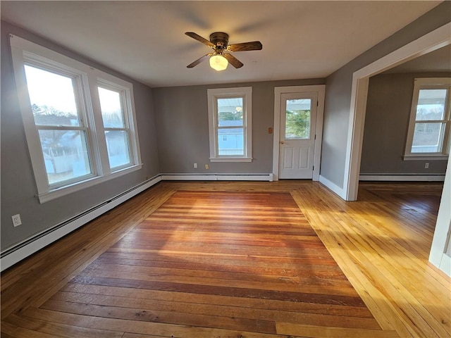 interior space with light hardwood / wood-style floors, ceiling fan, and a baseboard heating unit