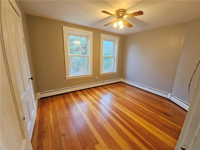 unfurnished room featuring ceiling fan, light wood-type flooring, and a baseboard heating unit