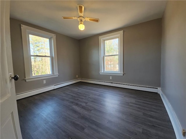 spare room with ceiling fan, dark wood-type flooring, and a baseboard heating unit