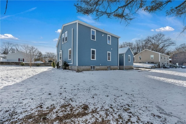 view of snow covered back of property