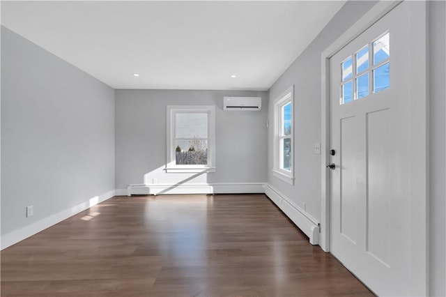 foyer entrance with a wall mounted air conditioner, dark wood-type flooring, a wealth of natural light, and a baseboard heating unit