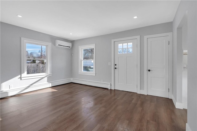 entryway featuring a wall mounted air conditioner, dark hardwood / wood-style floors, and a healthy amount of sunlight