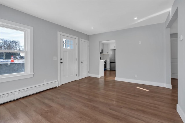 foyer featuring dark wood-type flooring and a baseboard heating unit