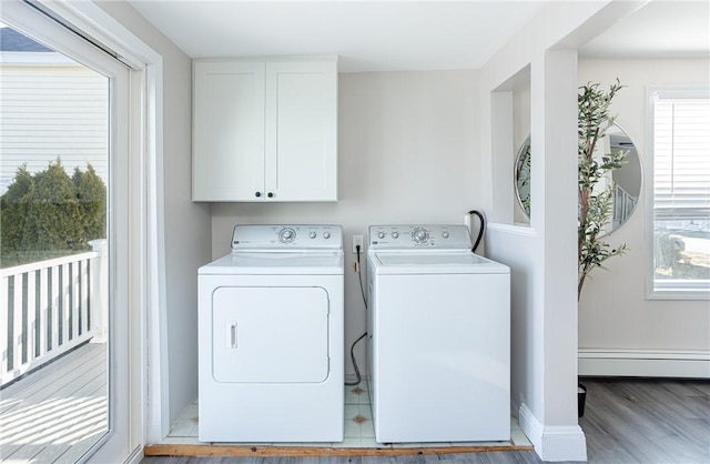 washroom with washer and clothes dryer, wood-type flooring, a healthy amount of sunlight, and a baseboard heating unit