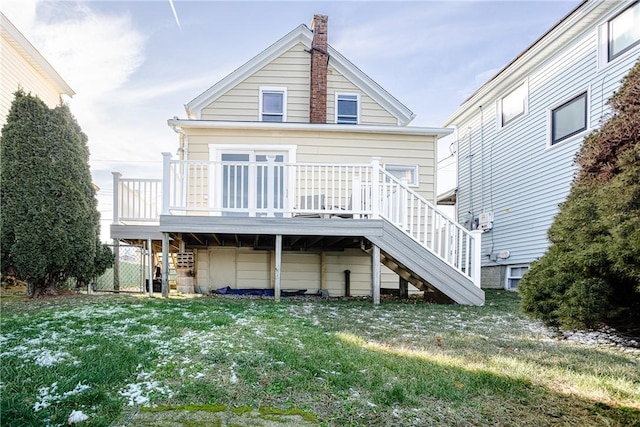 rear view of house featuring a deck and a lawn