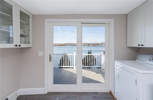 clothes washing area with cabinets, a water view, a baseboard radiator, plenty of natural light, and washer / dryer