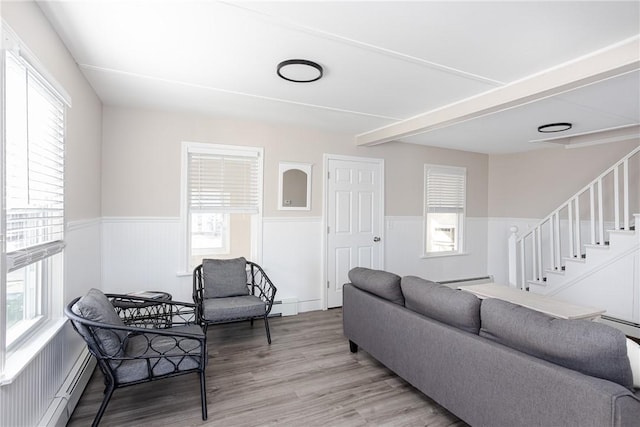 living room featuring wood-type flooring, a baseboard radiator, and a wealth of natural light