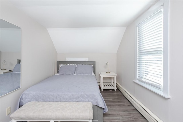 bedroom with multiple windows, baseboard heating, and vaulted ceiling