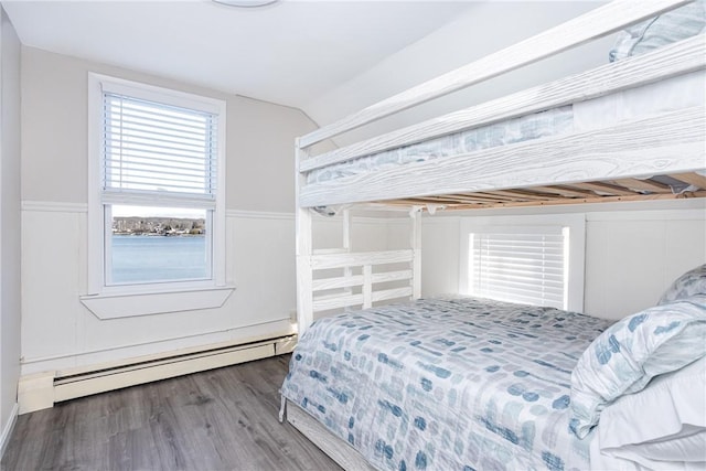 bedroom featuring wood-type flooring, lofted ceiling, and a baseboard radiator