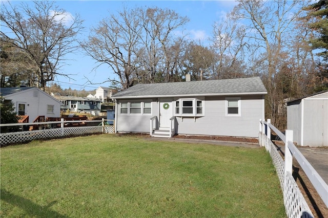 rear view of property with a shed and a yard