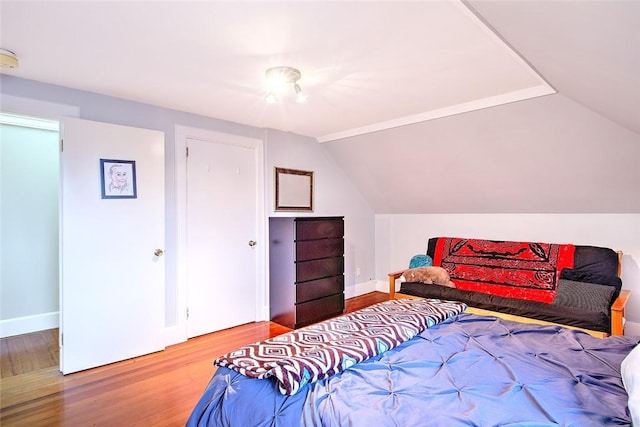 bedroom with wood-type flooring and lofted ceiling