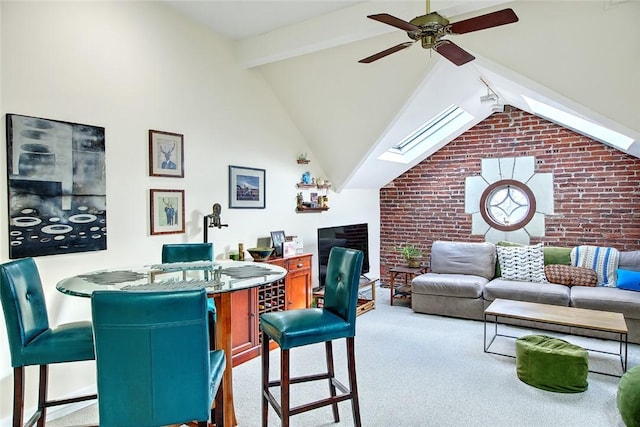 carpeted living room with beam ceiling, a skylight, high vaulted ceiling, and ceiling fan