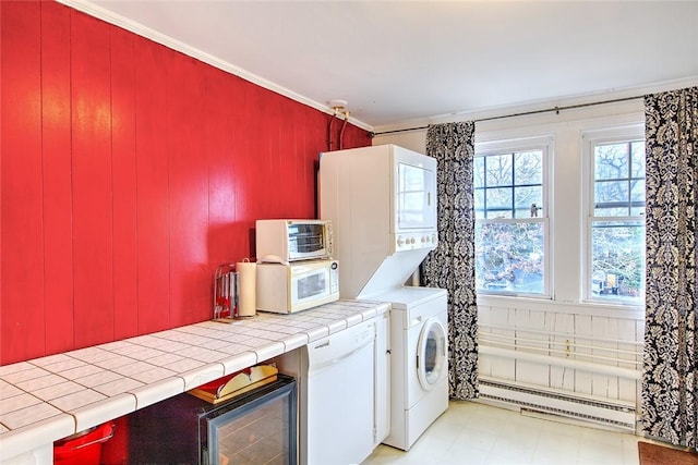 clothes washing area with stacked washer and clothes dryer, baseboard heating, and crown molding