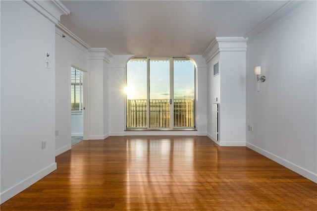 empty room with ornamental molding and hardwood / wood-style floors