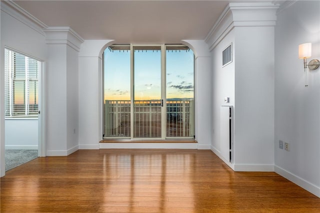 spare room featuring hardwood / wood-style flooring and ornamental molding