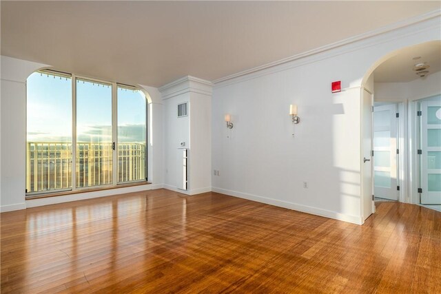 spare room featuring crown molding and hardwood / wood-style floors