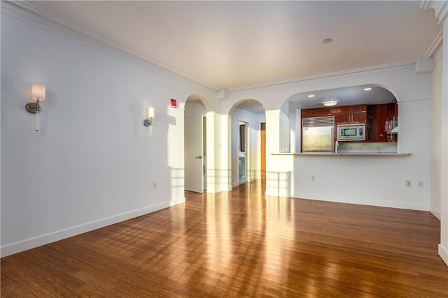 unfurnished living room featuring hardwood / wood-style flooring and crown molding