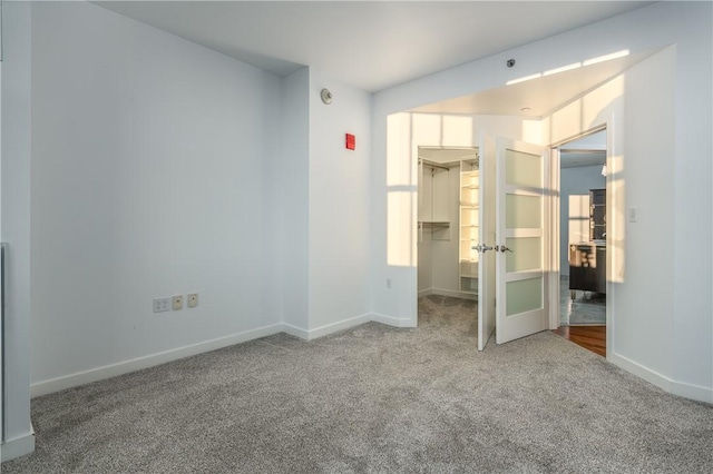 unfurnished bedroom featuring a walk in closet, carpet floors, and a closet