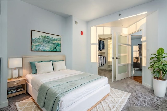 bedroom with carpet flooring, a closet, and a spacious closet