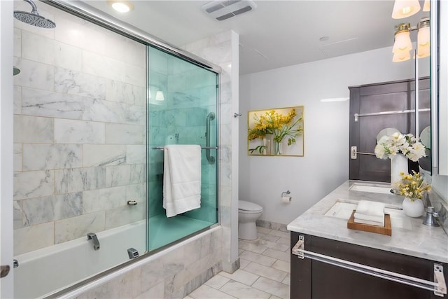 full bathroom featuring vanity, combined bath / shower with glass door, and toilet