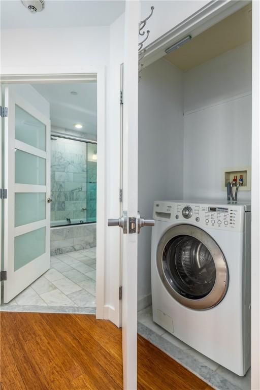 clothes washing area featuring washer / dryer and light hardwood / wood-style flooring