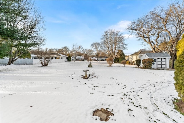 yard covered in snow featuring a storage shed