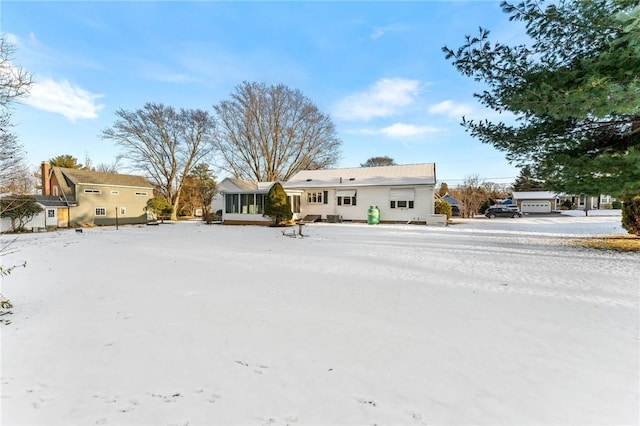 snow covered property featuring a sunroom