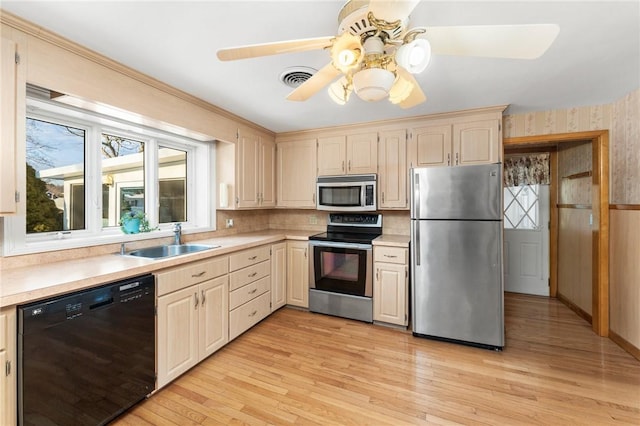 kitchen featuring ceiling fan, sink, stainless steel appliances, and light hardwood / wood-style flooring