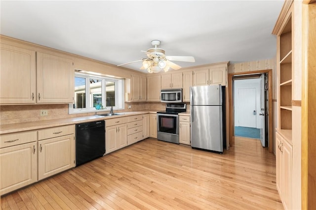 kitchen featuring ceiling fan, sink, light wood-type flooring, and appliances with stainless steel finishes