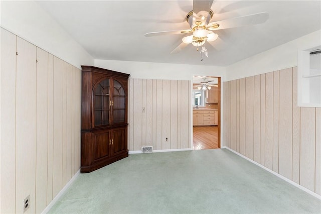 carpeted spare room featuring wooden walls