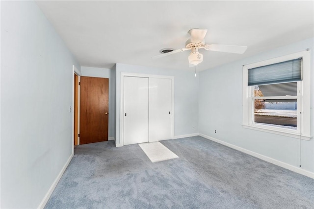 unfurnished bedroom featuring ceiling fan, light carpet, and a closet