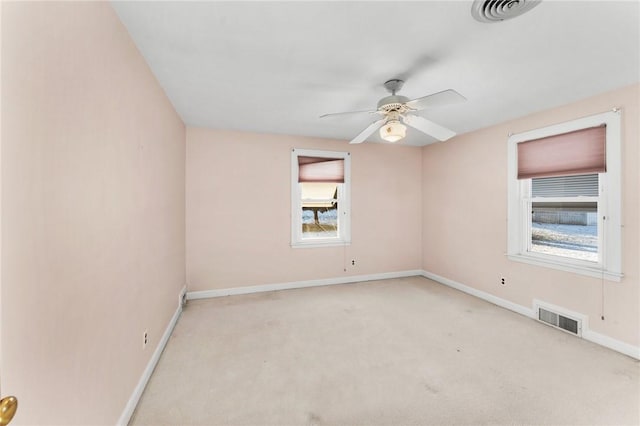 carpeted empty room featuring ceiling fan and plenty of natural light