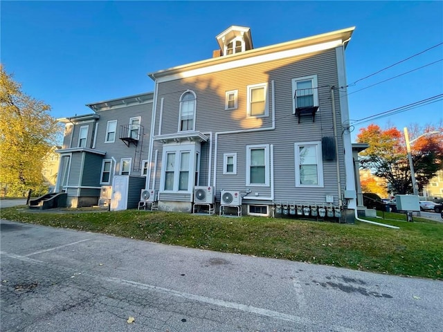 view of front facade with a front yard and ac unit