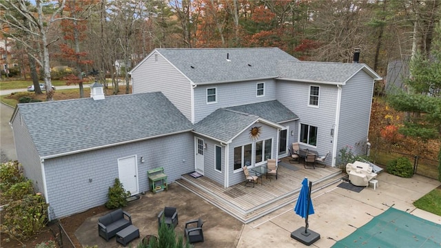 back of house with an outdoor living space, a patio area, and a swimming pool side deck