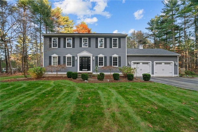 colonial-style house with a garage and a front lawn