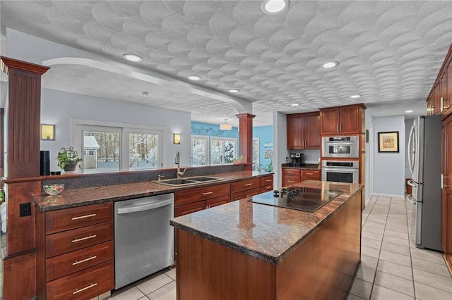 kitchen with sink, stainless steel appliances, decorative columns, a center island, and light tile patterned flooring