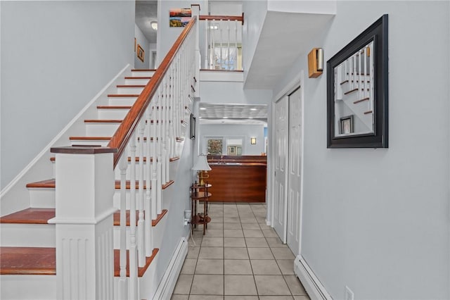 stairs with a baseboard radiator and tile patterned floors