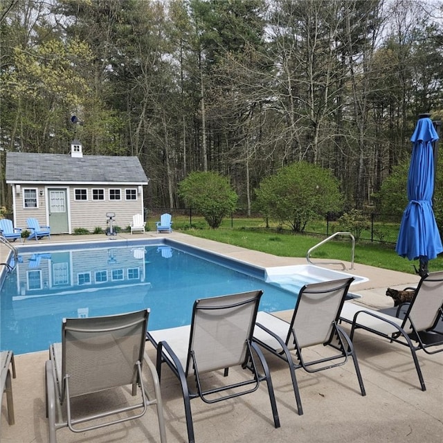 view of swimming pool featuring an outdoor structure, a patio, and a lawn