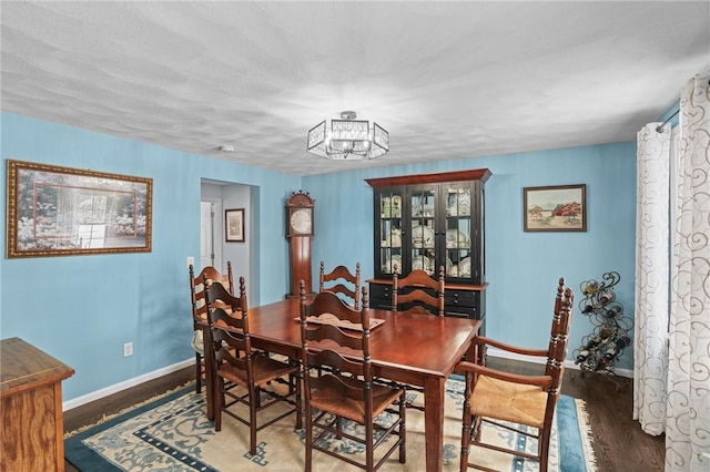 dining space featuring dark hardwood / wood-style flooring and a chandelier