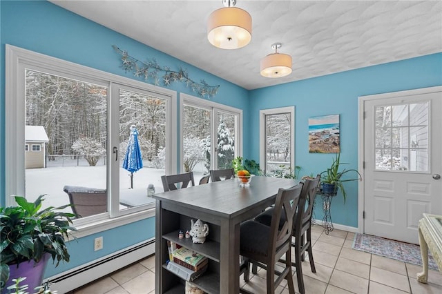 tiled dining space with a baseboard radiator and plenty of natural light