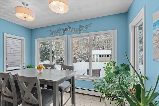 tiled dining room with a baseboard heating unit