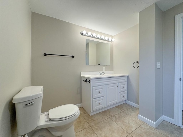 bathroom with toilet, vanity, and tile patterned floors