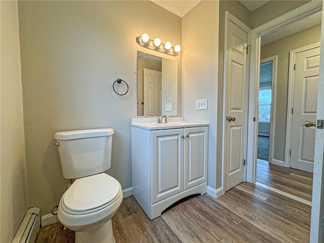 bathroom with vanity, a baseboard radiator, toilet, and hardwood / wood-style flooring